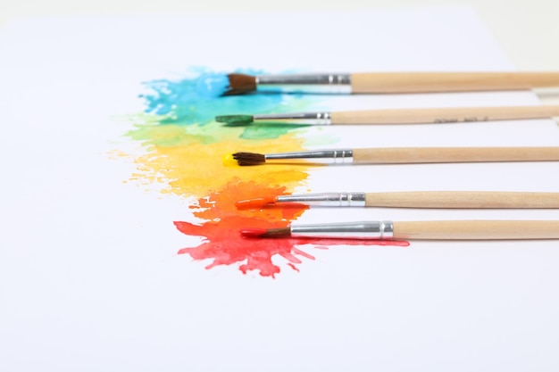 白い背景に色のついた絵の具としみが付いたブラシ
