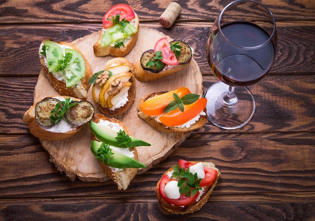 Brushetta set for wine. Variety of small sandwiches on wooden background