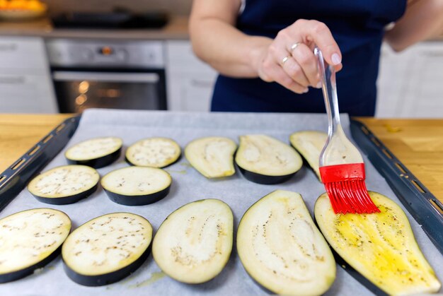 Brushing with oil sliced eggplant on a baking tray grilled eggplant appetizer cooking process