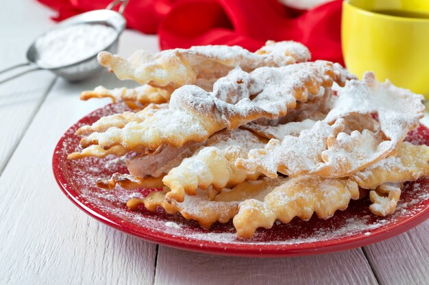 Brushwood  crispy deep fried cookies in powdered sugar with tea and jam