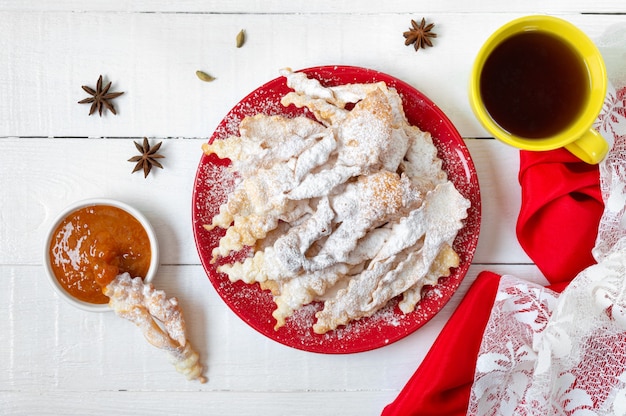 Brushwood  crispy deep fried cookies in powdered sugar with tea and jam