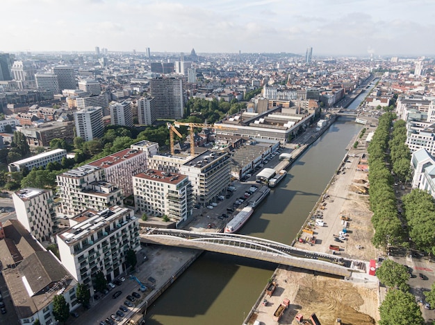 Brussel België 12 mei 2022 Stedelijk landschap van de stad Brussel Het Zennekanaal dat Brussel doorkruist en een brug voor fietsers en voetgangers in aanbouw Op de achtergrond de o