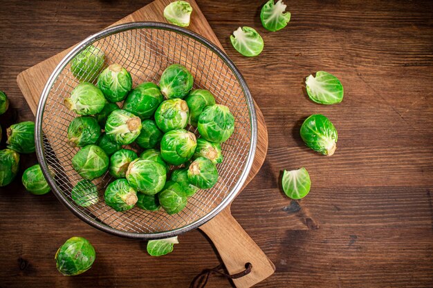 Brussel cabbage in a colander on a cutting board