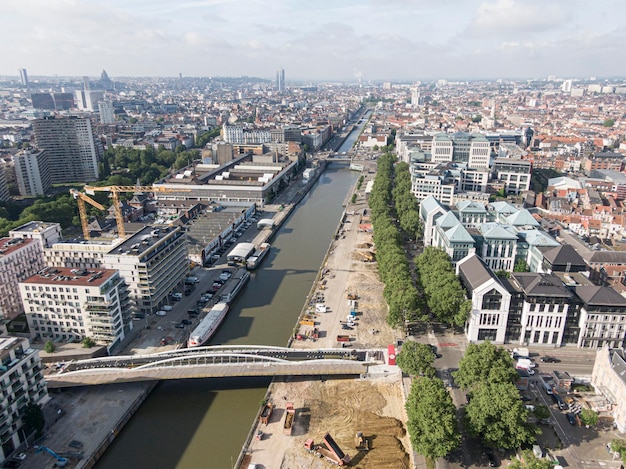 Brussels Belgium May 12 2022 Urban landscape of the city of Brussels The Senne river canal crossing Brussels and a bridge for cyclists and pedestrians under construction In the background the o