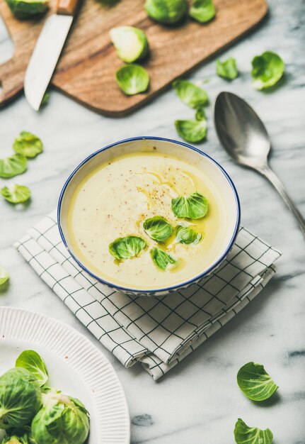 Photo brussels sprouts vegetable cream soup in bowl over marble table