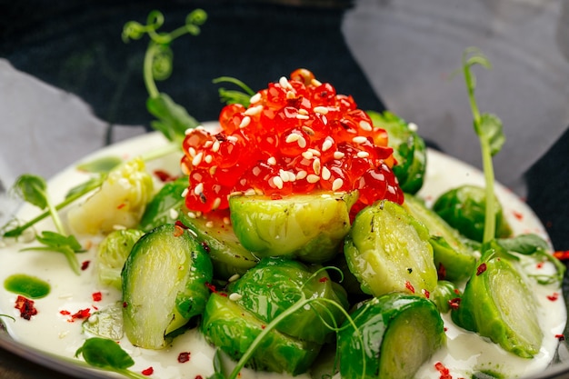 Brussels sprouts with caviar in a black bowl