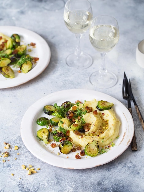 Brussels sprouts with pistachios, raisins and skordalia (mashed\
potatoes). healthy meal preparation. plant-based dishes. green\
living. vegan recipe. food styling. vegetarian cuisine. healthy\
eating