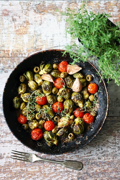 Brussels sprouts with vegetables and herbs in a pan