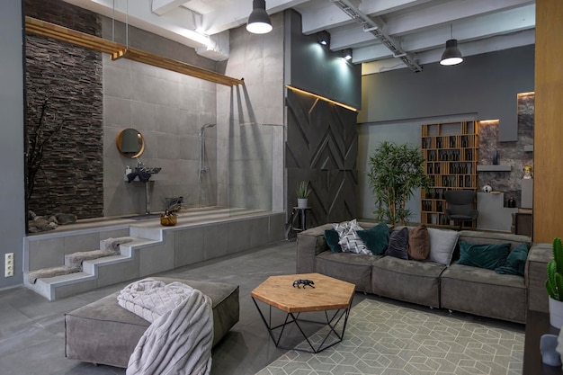 Brutaal ultra trendy interieur van een open appartement met een open douche versierd met grijze steen