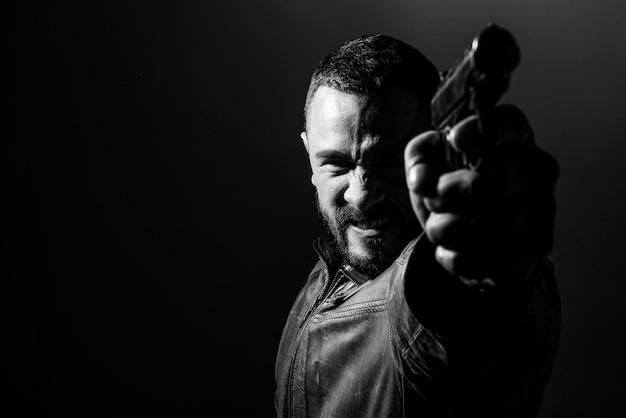 Жестокий злой бандитский образ жизни Гангстер в действии убийца целится из пистолета Парень стреляет из огнестрельного оружия пистолет Макарова в тире