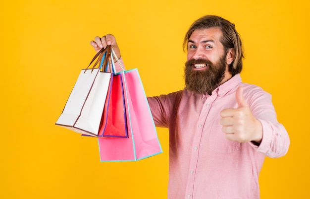 Brutal bearded male man hold present or gift package, black friday.