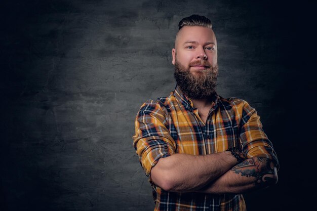 Brutal bearded male with crossed arms, dressed in a yellow plaid shirt.