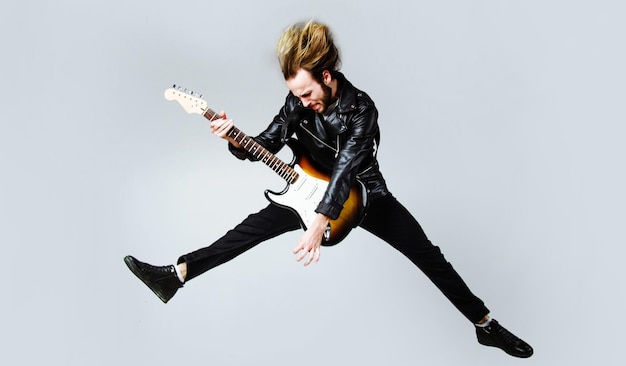 Brutal bearded man jumping with electric guitar rock musician\
heavy metal player music star