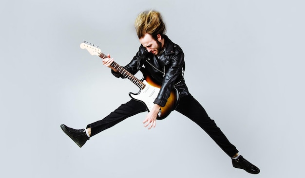 Brutal bearded man jumping with electric guitar rock musician
heavy metal player music star