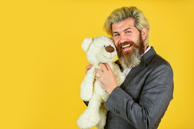 Brutal bearded man ready for romantic date valentines day gift man in jacket hold teddy bear bizarre people concept businessman play with toy soothing toy with autism copy space