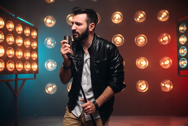 Фото Брутальный бородатый певец с микрофоном на сцене