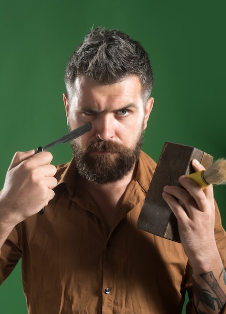 Brutal caucasian hipster bearded man with long beard with beard and moustache holds in the hands