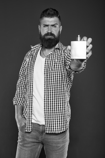 Photo brutal caucasian hipster with moustache male fashion facial care mature hipster with beard man presenting perfume product aroma and smell bearded man got to shave