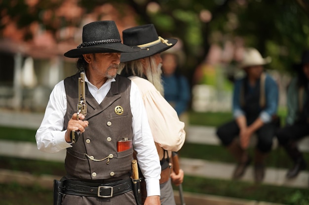 Brutal cowboy with revolver gunfight on ranch rural background