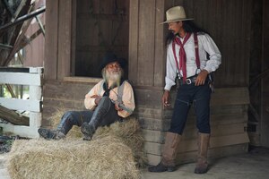 Brutal cowboy with revolver gunfight on ranch rural background