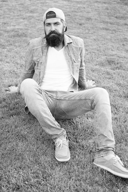 Brutal handsome hipster man resting on summer day Bearded man trendy hipster style Guy modern outfit Casual and comfortable Hipster lifestyle Cool hipster with beard wear stylish baseball cap