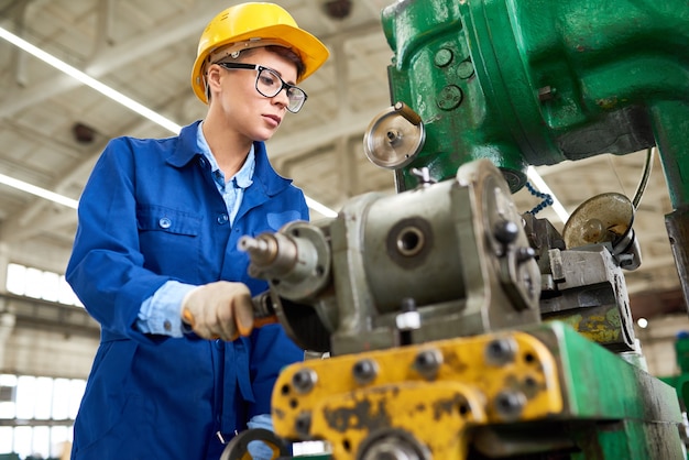 Brutal lady adjusting machine before operation