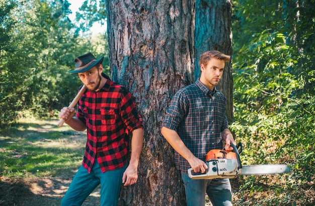 Photo brutal lumberjacks cutting wood brutality and masculinity lumberjack style man woodcutter with axe strong man with axe