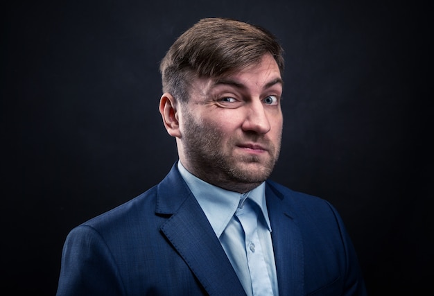 Brutal man in suit on black wall