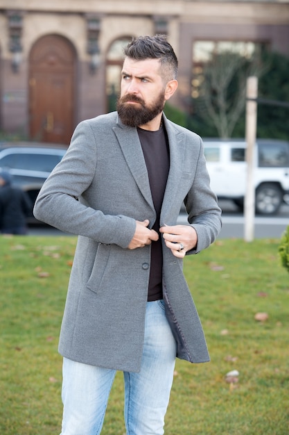 Brutal mature bearded man with moustache walking outdoor in trendy modern casual jacket, perfect style.