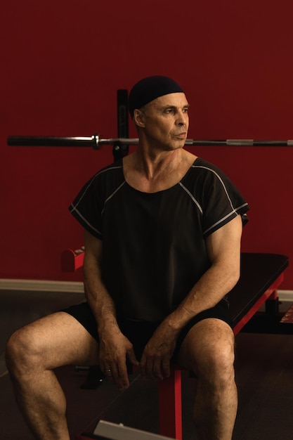 Photo brutal middleaged man trains in the gym