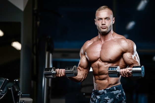 Brutal strong bodybuilder athletic men pumping up muscles with dumbbells