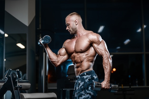 Brutal strong bodybuilder athletic men pumping up muscles with dumbbells