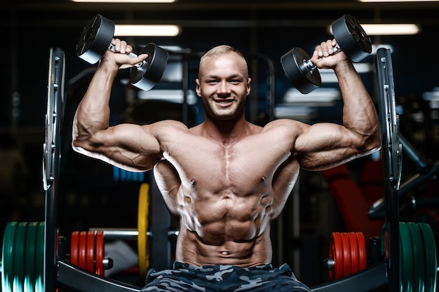 Brutal strong bodybuilder athletic men pumping up muscles with dumbbells