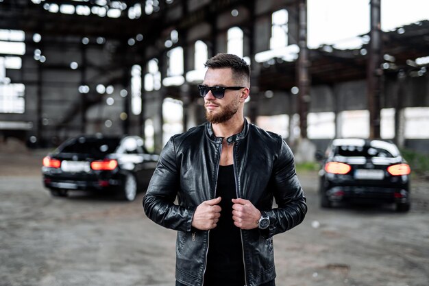 Brutal successful man in leather jacket Stylish man in biker black jacket and sunglasses