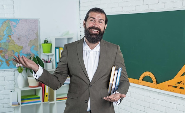 Foto docente universitario brutale con la barba lunga nell'istruzione in classe