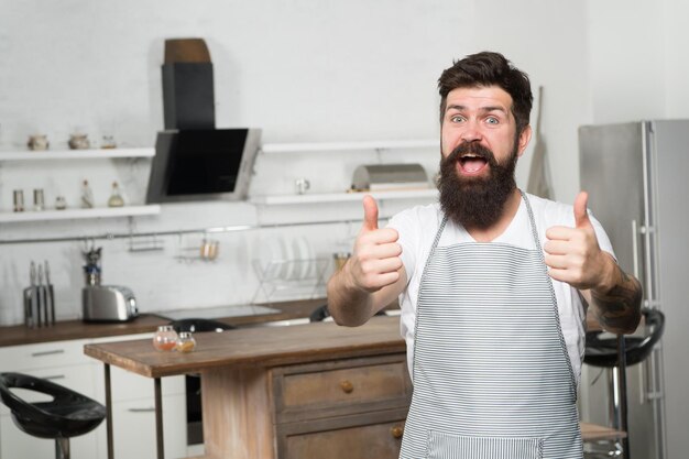 Brutale zelfverzekerde chef-kok in restaurant Hipster-bebaarde mannelijke chef-kok die eten kookt in de keuken Keuken voor echte mannen Lekker eten thuis koken Thuis eten Beveel mooi recept aan Culinaire zaken