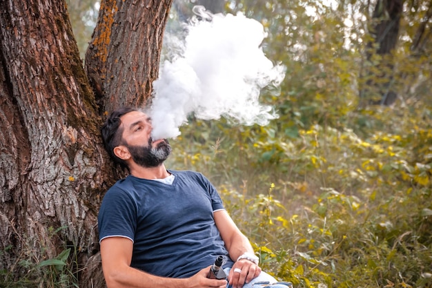 Brutalvaper laat een wolk van stoom vrij in de rustige buitenlucht. Vapen concept.