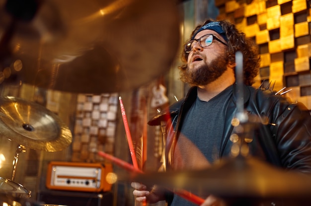 Brute drummer die op drumstel speelt, muziek op het podium. Rockbanduitvoering of herhaling in garage, man met muziekinstrument, live geluidsartiest