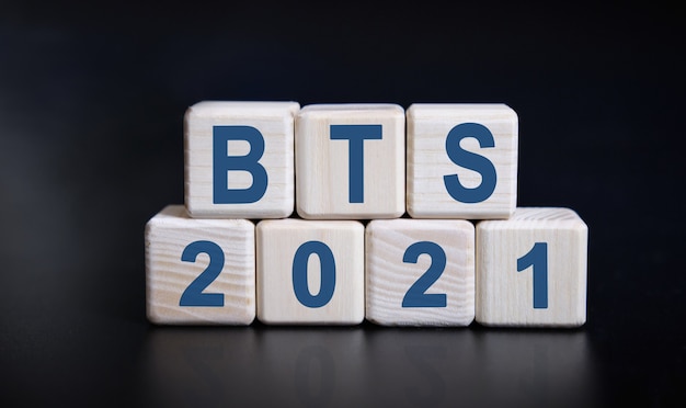 Текст bts 2021 на деревянных кубиках на черном фоне с отражением.