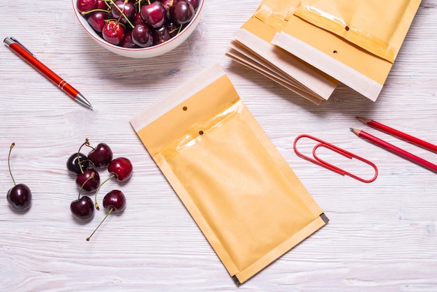 Bubble Envelopes on wooden table with cherry, summer concept