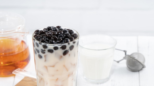 Bubble melkthee met tapioca parel topping, beroemde Taiwanese drank op witte houten tafel achtergrond in drinkglas, close-up, kopie ruimte