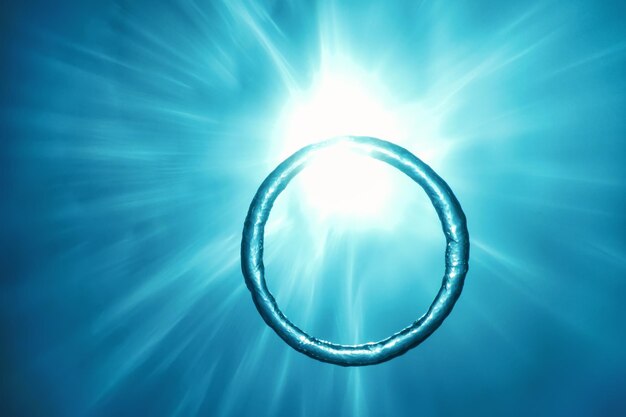 Photo bubble ring underwater ascends towards the sun.