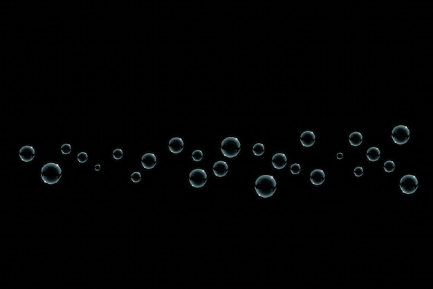 bubbles are floating in the dark on a black background