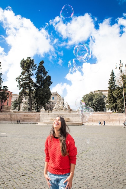 Bubbles over cheerful woman standing in city