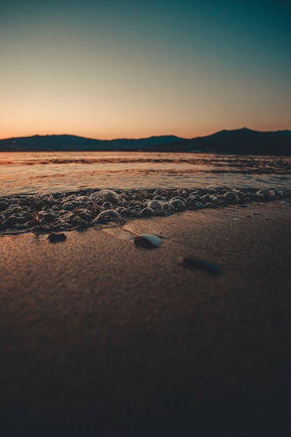 Bubbles on the sand during a dark sunset