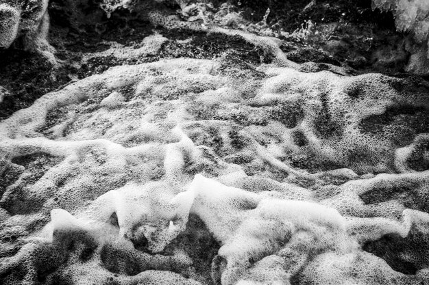 Бурлящая вода с пеной и брызгами. черно-белое фото. Фото высокого качества