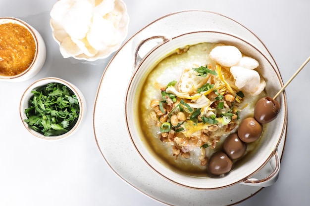 Bubur Ayam of Indonesische rijstepap met geraspte kip en cakwe.