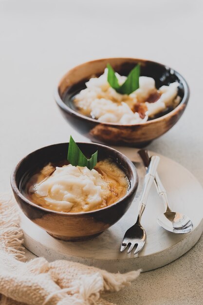 부부르 썸썸. 쌀가루로 만든 자바식 디저트 죽, 야자 설탕 시럽을 곁들인 코코넛 밀크. 나무 그릇에 제공됩니다. 라마단 기간 동안 단식을 깨기 위한 인기 있는 스타터 음식입니다.