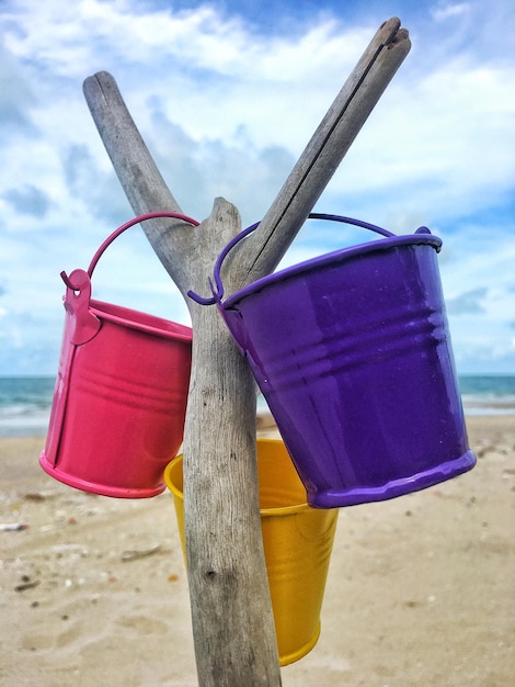 Foto il secchio era appeso a un ramo asciutto dietro la spiaggia e il mare il cielo era blu scuro con le nuvole