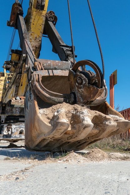 The bucket of an old quarry excavator is a closeup the crawler\
excavator is located on the territory of a mining quarry an open\
method of mining